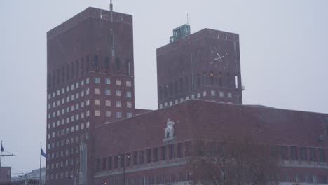Snow-Falling-With-View-Of-Oslo-City-Hall-Towers-In-Background-On-Winter-Day