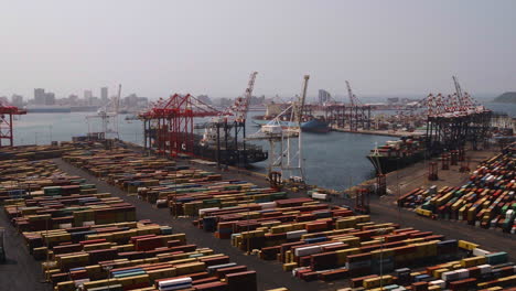 Aerial-drone-shot-towards-three-cargo-container-ships-being-loaded-by-gantry-cranes-in-Durban-Harbour