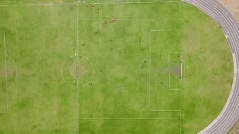 Top-down-aerial-footage-of-soccer-players-coming-off-the-field-on-a-soccer-field-in-HueHuetenango,-Guatemala