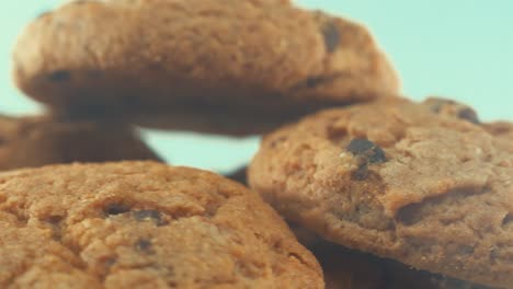 A-macro-shot-of-a-white-plate-full-of-tasty-chocolate-chip-cookies,-on-a-360-rotating-stand,-studio-lighting,-slow-motion,-4K-video