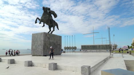 Young-Child-Rides-Skateboard-Next-to-Alexander-the-Great-Statue-in-Thessaloniki
