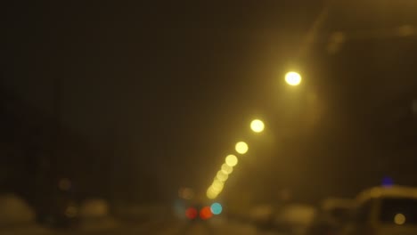 Yellow-color-streets-lights-glowing-at-nigh-time,-driving,-blurry-view