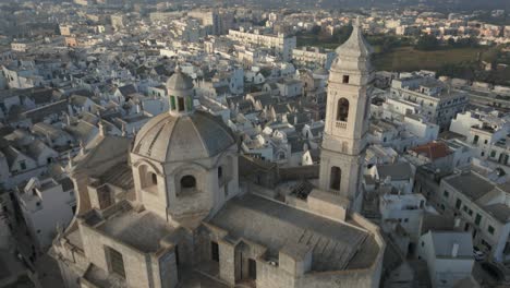 Drone-flying-over-medieval-city-Locorotondo-reveals-the-dome-and-tower-of-the-Chiesa-Madre-di-San-Giorgio-Martire