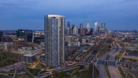 Rising-aerial-hyperlapse-of-The-Confluence-apartment-complex-in-the-evening-with-downtown-Denver,-Colorado-in-the-distance