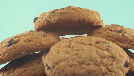 A-macro-close-up-shot-of-a-white-plate-full-of-chocolate-chip-cookies,-on-a-360-rotating-stand,-studio-lighting,-slow-motion,-4K-video