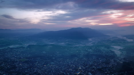 Wide-aerial-footage-in-the-blue-light-of-the-sunrise-of-the-city-of-San-Juan-Ostuncalco-and-the-mountains-behind-it-in-the-haze