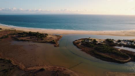 Drone-shot-of-a-river-feeding-into-the-Alboran-Sea-in-Tarifa,-Spain