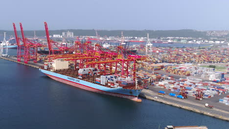 Breite-Luftdrohnenaufnahme-Eines-Großen-Containerschiffs,-Das-Von-Portalkränen-Beladen-Wird-Durban,-Südafrika