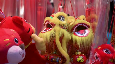 Chinese-New-Year-decorative-ornaments,-such-as-yellow-lions,-seen-for-sale-at-a-shop-during-the-Lunar-Chinese-New-Year-in-Hong-Kong