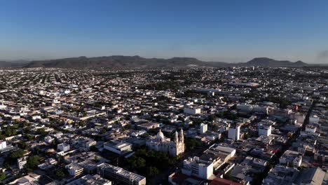 Aerial-overview-of-the-cityscape-of-Culiacan,-in-sunny-Mexico---circling,-drone-shot