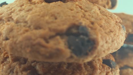 A-macro-close-up-shot-of-a-white-plate-full-of-well-baked-chocolate-chip-cookies,-on-a-360-rotating-stand,-studio-lighting,-slow-motion,-4K-video