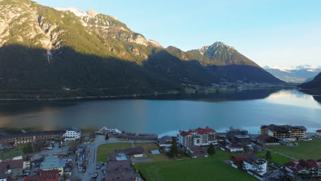 Montañas-Escénicas-Y-Pueblo-A-Orillas-Del-Lago-Achensee-En-Tirol,-Austria---Toma-Aérea-De-Drones