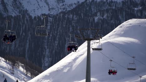 Ski-lift,-chair-lift-with-skiers-in-the-cold-alps,-Austria