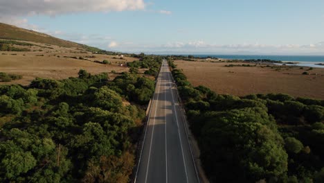 Drone-shot-of-the-E-5-highway-running-along-Spain's-coastline-at-sunset
