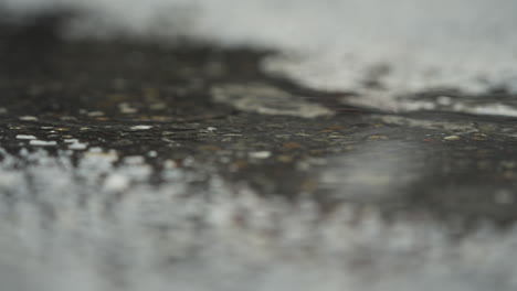 Static-close-up-shot-of-rain-in-puddle-of-water-on-streets