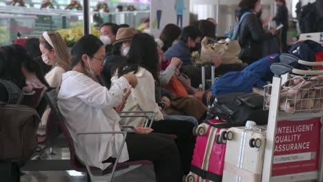 Passengers-and-Chinese-tourists-sit-at-the-departure-hall-in-Hong-Kong-Chek-Lap-Kok-International-Airport