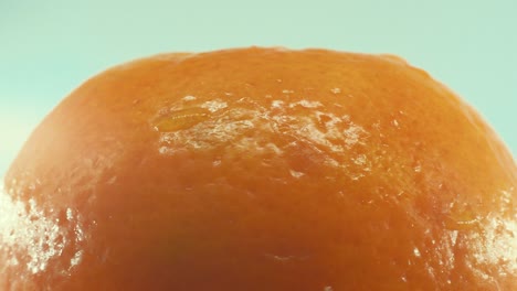 Eine-Makroaufnahme-Einer-Clementine-Orangenfrucht-Auf-Einem-Rotierenden-360-Grad-Ständer,-Studiobeleuchtung,-Zeitlupe,-4k-Video