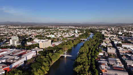 Aerial-overview-of-the-Río-Tamazula-river,-in-sunny-Culiacan,-Mexico---circling,-drone-shot