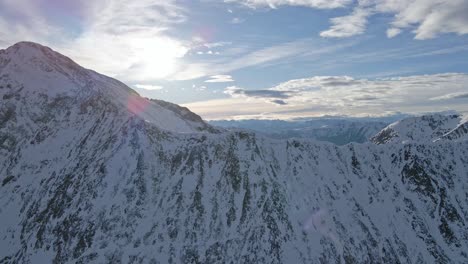 Drone-footage-of-snowy-pyrenees-mountains-with-the-sun-and-clouds