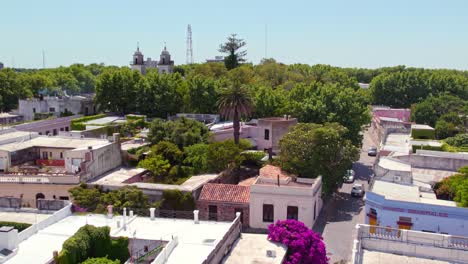 Dolly-in-aerial-view-of-Colonia-del-Sacramento-with-cobblestone-streets-and-the-basilica-church-of-the-santísimo-sacramento-on-a-sunny-day,-slow-motion