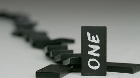 row-of-black-dominoes-with-one-in-front-with-a-word-on-it
