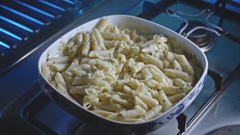 Macaroni-and-cheese-served-in-a-porcelain-dish-on-the-kitchen-stove