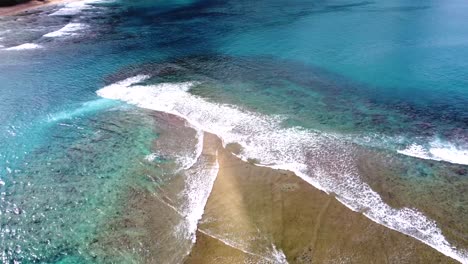 Vista-Aérea-De-Las-Olas-Rompiendo-Sobre-El-Arrecife-De-Coral-Tropical-En-Kauai,-Hawaii,-Estados-Unidos