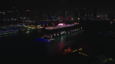 Beautiful-establishing-view-of-cruise-ship-against-night-cityscape-of-Miami