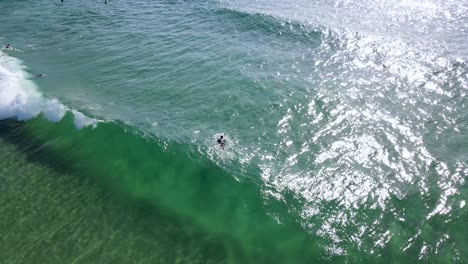 Luftdrohnenszene-Eines-Surfers,-Der-Bereit-Ist,-Eine-Welle-Im-Meer-Zu-Fangen-Person,-Die-Im-Meer-Trainiert,-Um-In-Florianópolis-Zu-Surfen