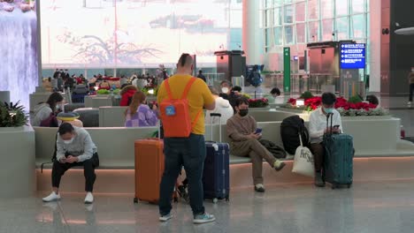 Passagiere-Und-Touristen-Sitzen-In-Der-Ankunftshalle-Des-Internationalen-Flughafens-Hong-Kong-Chek-Lap-Kok,-Da-Hong-Kong-Die-Beschränkungen-Für-Reisende-Lockert