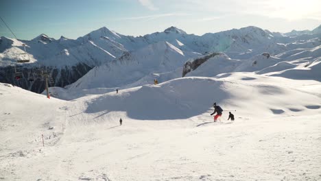 Skifahrer,-Die-An-Einem-Sonnigen-Wintertag-Eine-Weiße,-Saubere-Piste-Neben-Einem-Skilift-In-Den-Weißen,-Schneebedeckten-Schweizer-Alpen-Hinunterfahren