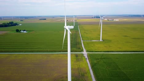 Aerial-view-orbiting-alternative-energy-wind-turbines-across-Lafayette,-Indiana-patchwork-farmland-landscape