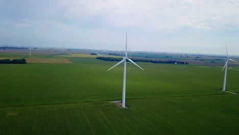 Aerial-view-Lafayette-agricultural-farmland-with-wind-turbines-blades-rotating-across-Indiana-countryside