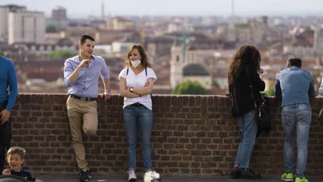 Touristen,-Die-Durch-Die-Mauer-Mit-Der-Stadt-Turin-Italien-Im-Hintergrund-Chillen