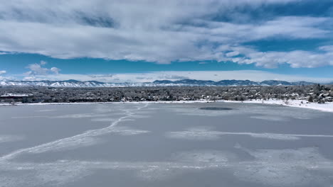 Die-Aufsteigende-Antenne-Des-Sloan-Lake-In-Denver,-Der-über-Freiliegenden,-Mit-Schnee-Bedeckten-Wohnhäusern-Zugefroren-Ist