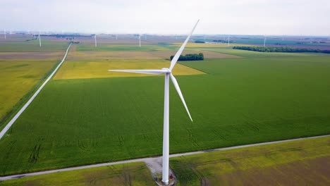 Aerial-view-orbiting-renewable-energy-wind-turbines-spinning-on-Lafayette,-Indiana-agricultural-farmland
