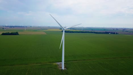 Vista-Aérea-Pasando-Turbinas-Eólicas-De-Energía-Sostenible-A-Lo-Largo-De-Lafayette,-Campo-De-Tierras-De-Cultivo-De-Indiana