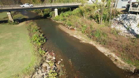 Aerial-pass-under-bridge-following-creek-in-Old-Town-Helena,-Alabama