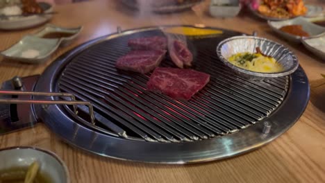 Close-up-of-meat-cooking-on-a-hot-Korean-Barbeque-grill