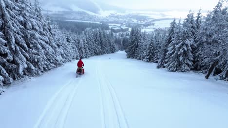 Rider-Riding-a-Snowmobile-in-Winter-wonderland---Drone-Follow-shot