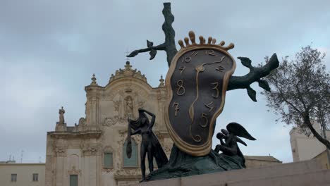 Escultura-De-Reloj-En-Matera,-Italia-Con-Video-Panorámico-De-Derecha-A-Izquierda