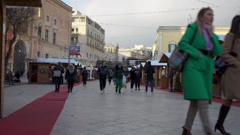Market-in-Matera,-Italy-with-people-walking-around-with-stable-establishing-video-shot