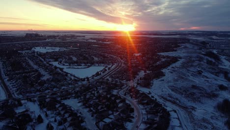 Fliegende-Drohne-In-Calgary-Während-Eines-Wunderschönen-Wintersonnenaufgangs-Mit-Gottstrahlen-über-Der-Gemeinschaft