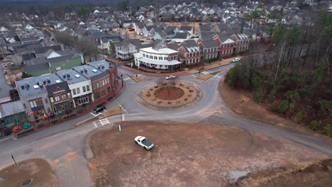 Aerial-pan-of-small-town-shops-and-roundabout-in-front-of-suburban-area-at-Moss-Rock-Preserve-in-Hoover,-Alabama