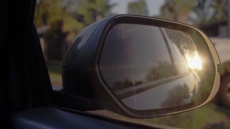 Zeitlupenclip-Des-Sonnenuntergangs,-Der-Auf-Dem-Außenspiegel-Eines-Fahrenden-Autos-Reflektiert-Wird