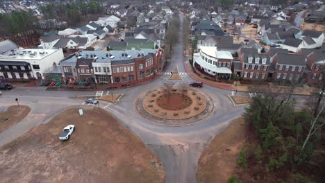 Aerial-approaching-small-town-shops-and-roundabout-in-front-of-suburban-area-at-Moss-Rock-Preserve-in-Hoover,-Alabama