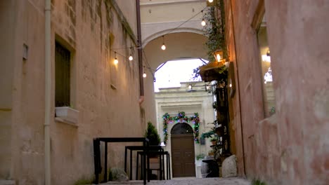 Tables-and-lights-in-an-alley-in-Matera,-Italy-with-establishing-video-shot