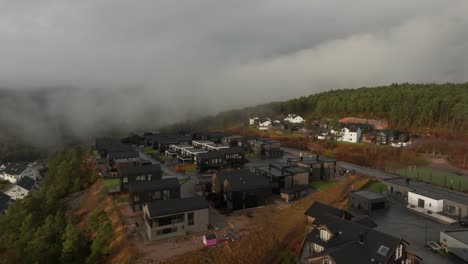 Drohnenaufnahmen-Von-Wohnsiedlungen-In-Norwegen-Mit-Etwas-Nebel-In-Der-Luft-Und-Sonne,-Die-Die-Wolken-Erhellt