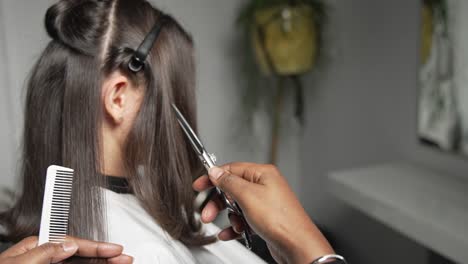 Hair-dresser-cutting-black-hair-with-Scissors