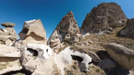 Stunning-aerial-flying-through-the-historical-turist-site-of-Cappadocia-Turkey-on-a-beautiful-summer-day-with-blue-skies
